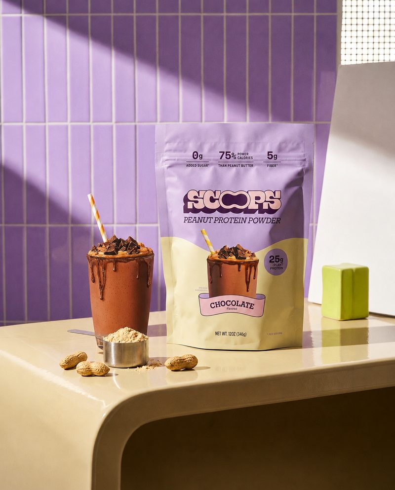 A bag of Scoops Chocolate peanut protein powder above a chocolate shake dripping down the glass